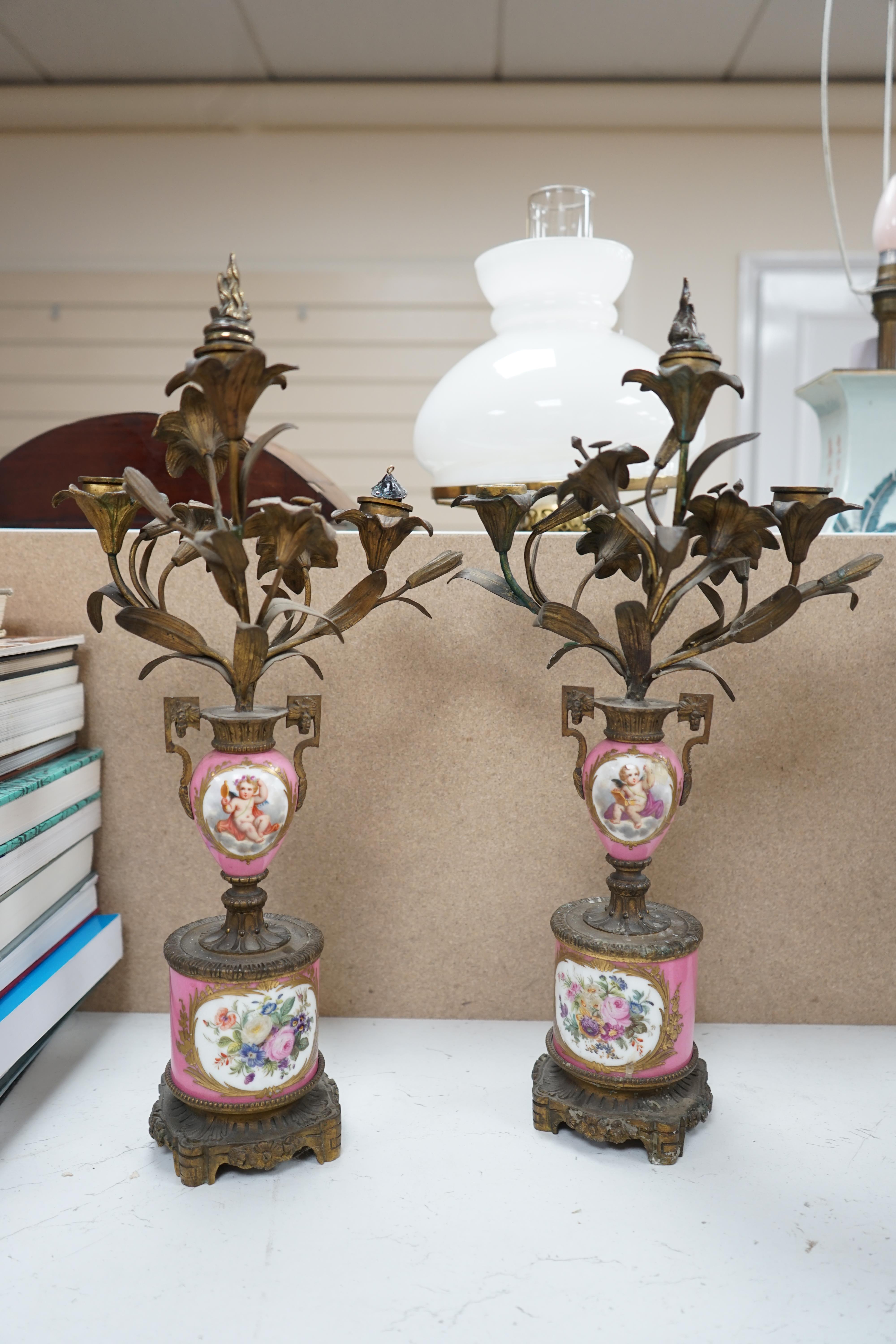 A pair of French porcelain mounted gilt metal candelabra and one other pair, tallest 45cm. Condition - fair